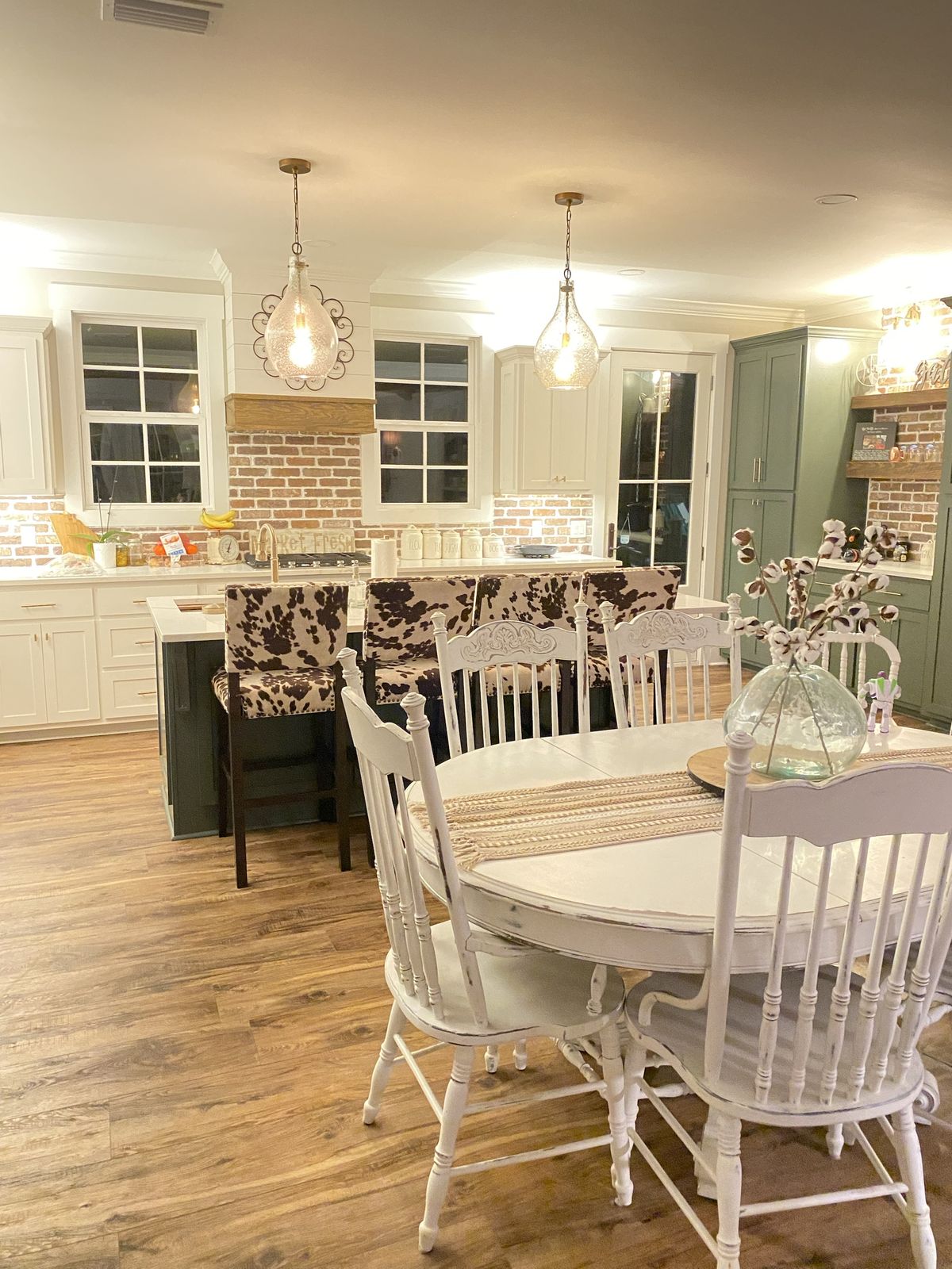 Farmhouse kitchen. Brick backsplash, painted island, and green built-in cabinetry.