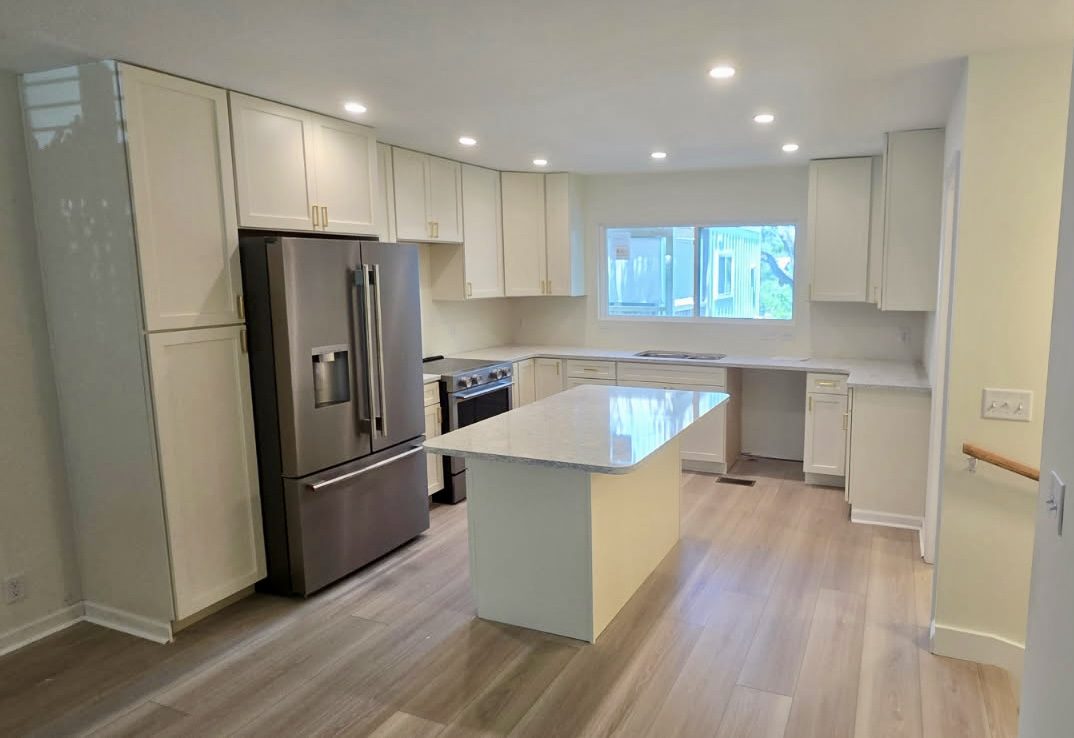 Kitchen. The same kitchen from the entry, with the island and full-height pantry cabinets.