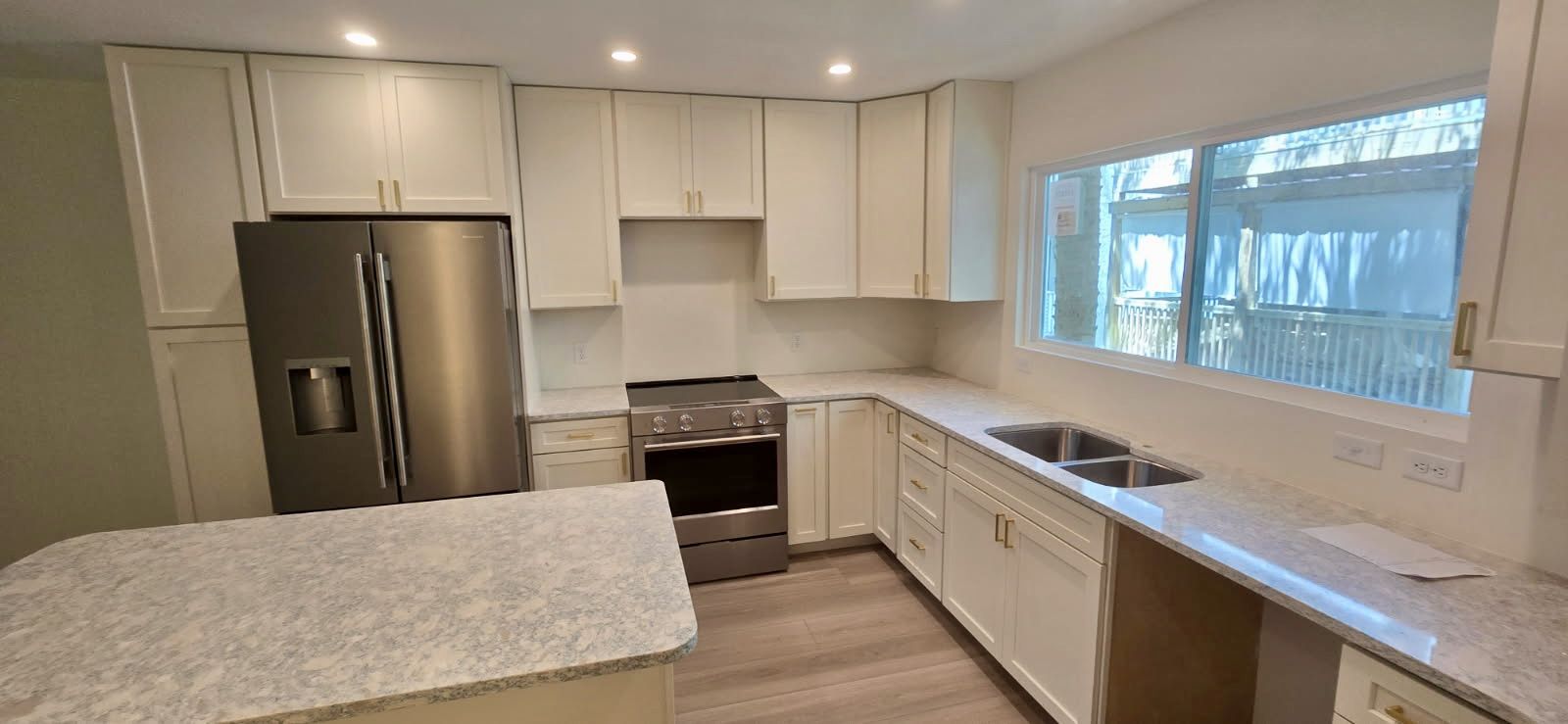 Kitchen. White shaker cabinets, quartz counters, and an island.