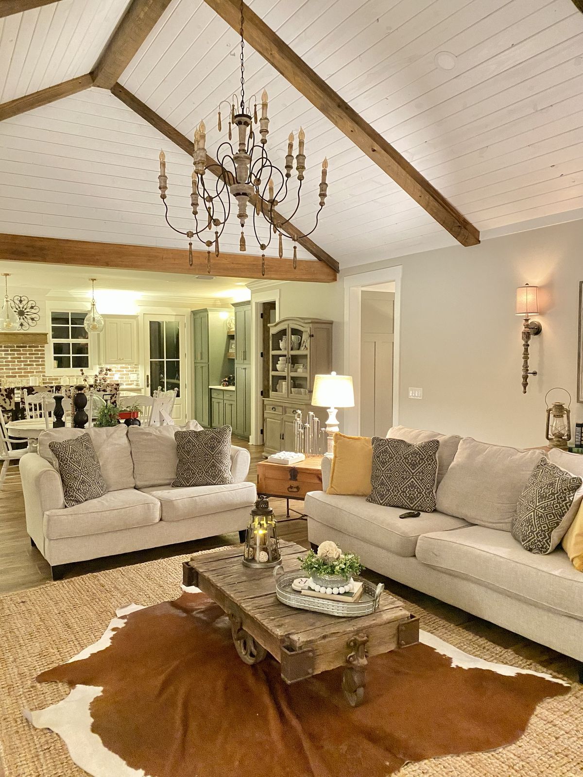 Living room. Vaulted shiplap ceiling with stained wood beams, open to the kitchen.