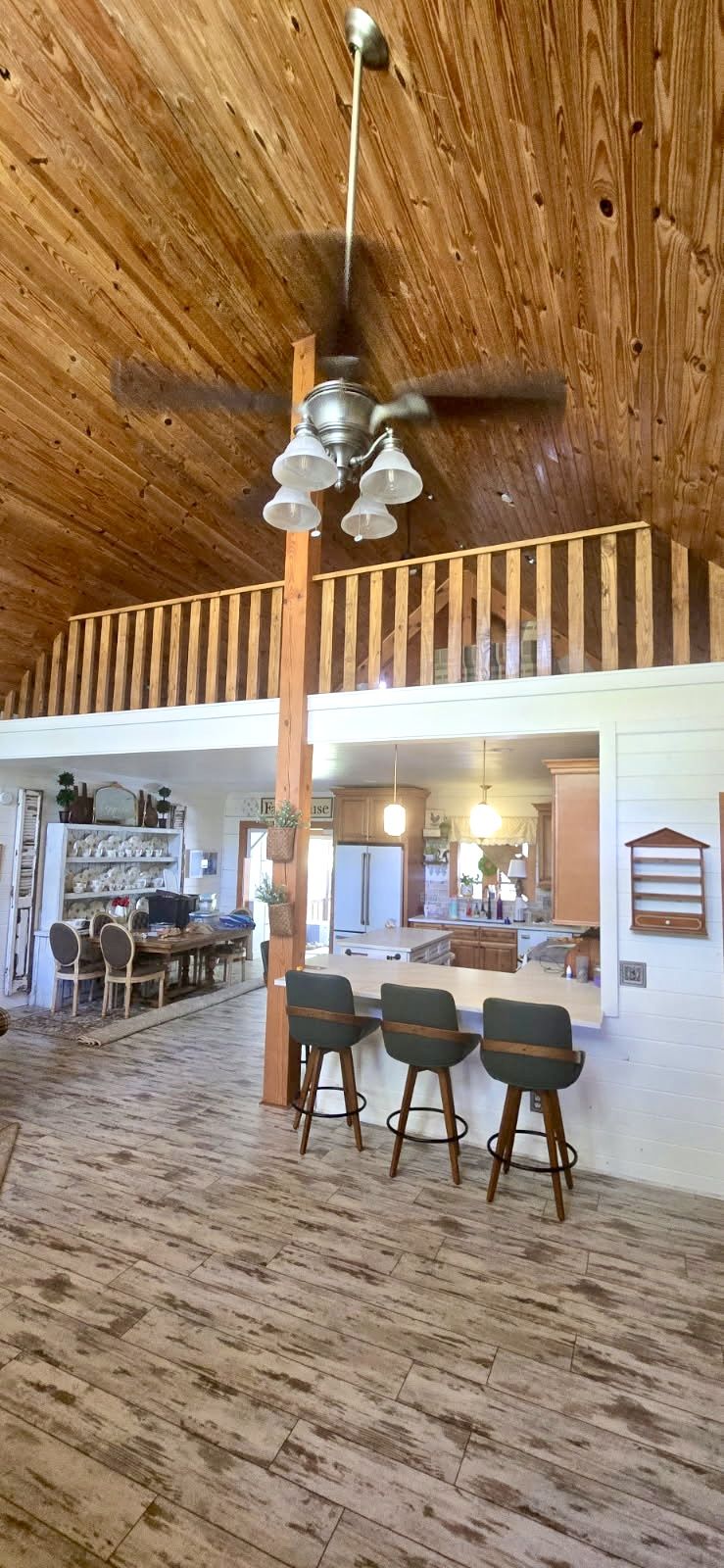 Loft and kitchen bar. Wood-railed loft overlooking the kitchen and dining area.